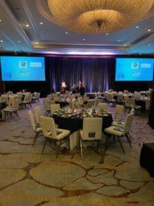 Ballroom set up for an event with tables and chairs.